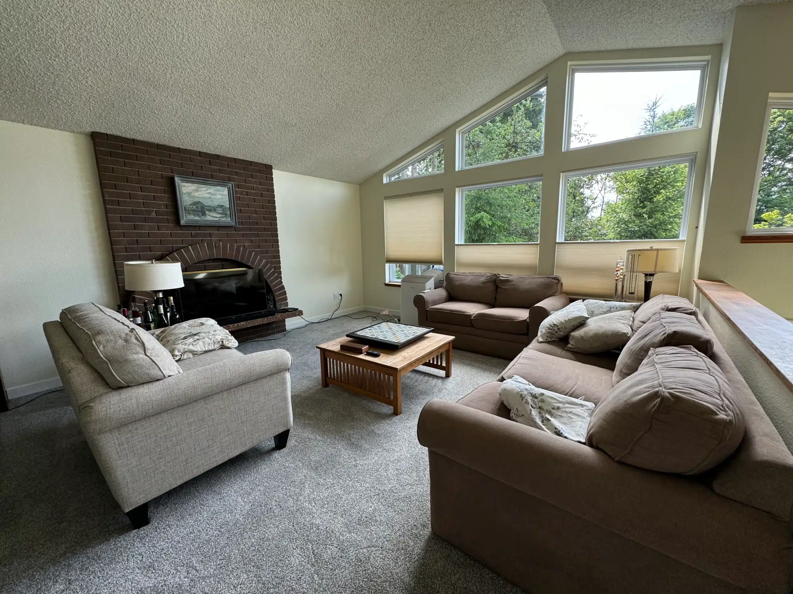 Living Room Interior Painting with Warm Wall Colors and Fireplace A spacious living room with light yellow walls, a brick fireplace, and comfortable sofas.
