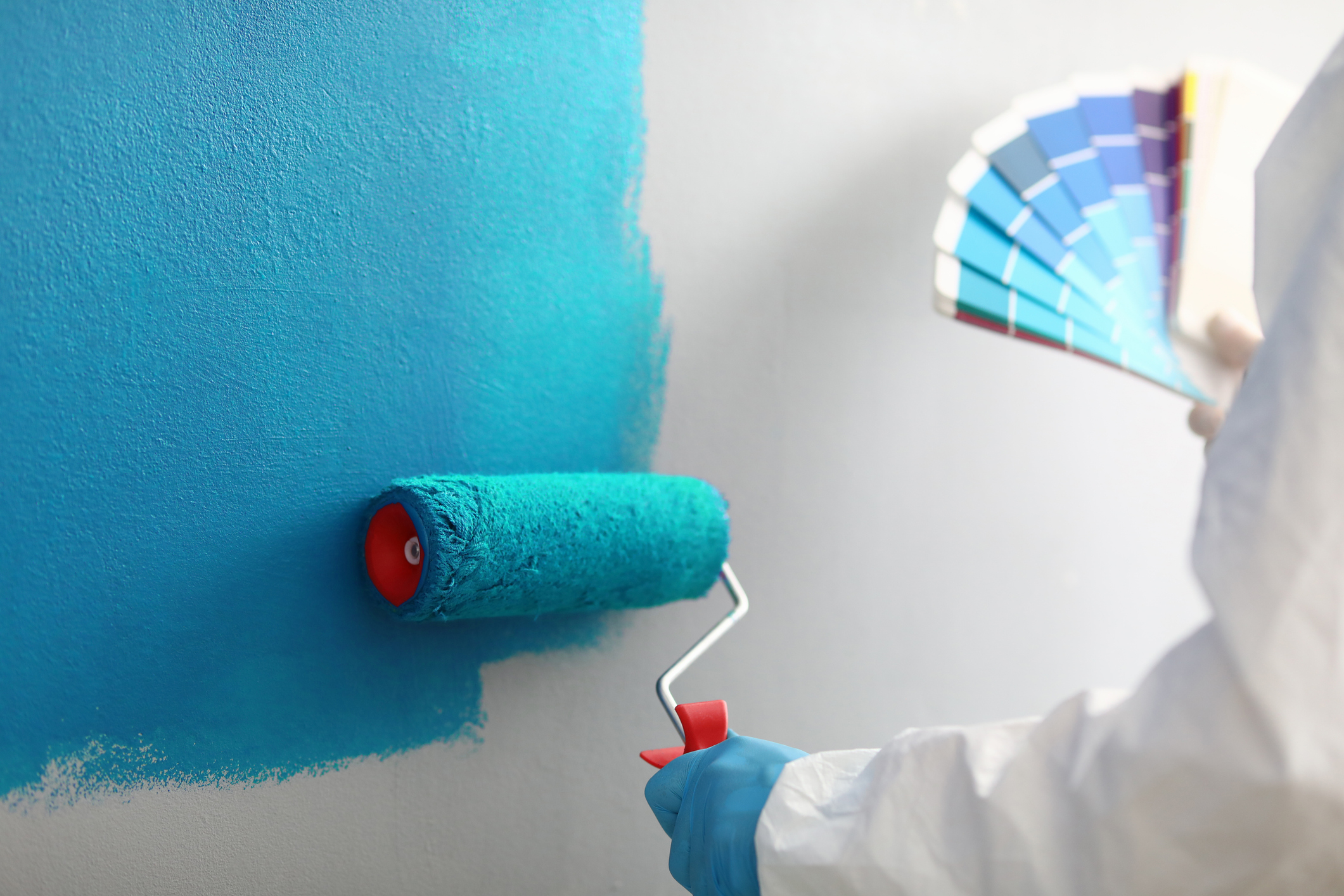 Master painter holds in his hands color palette with shades of blue how to paint textured walls