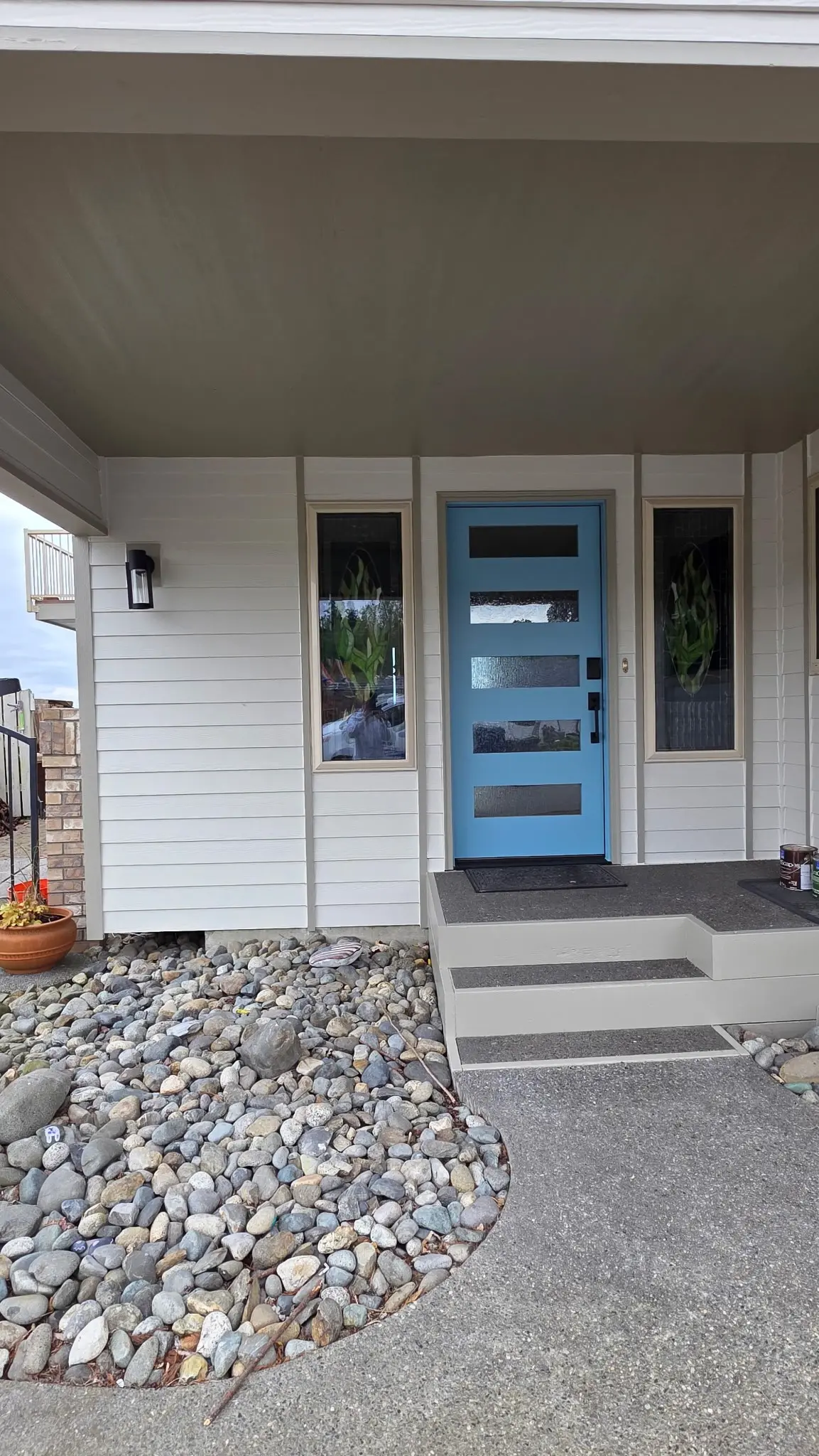 Modern Home Exterior Painting with Bright Blue Front Door A freshly painted modern home exterior featuring white siding and a vibrant blue front door.