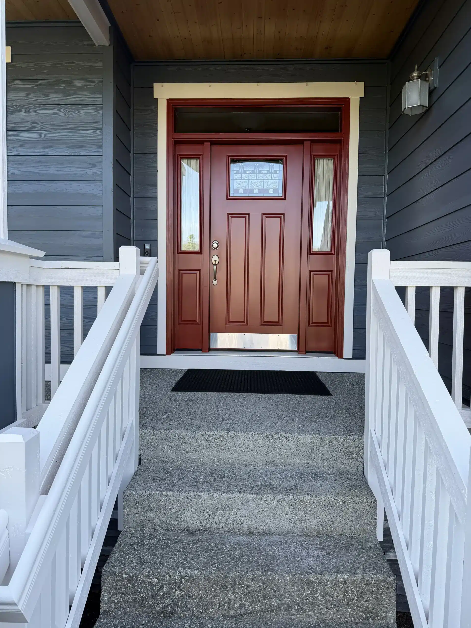 Striking Front Door Painting with Dark Gray Siding and White Trim A vibrant red front door with white trim and dark gray siding, enhancing the home's entrance.
