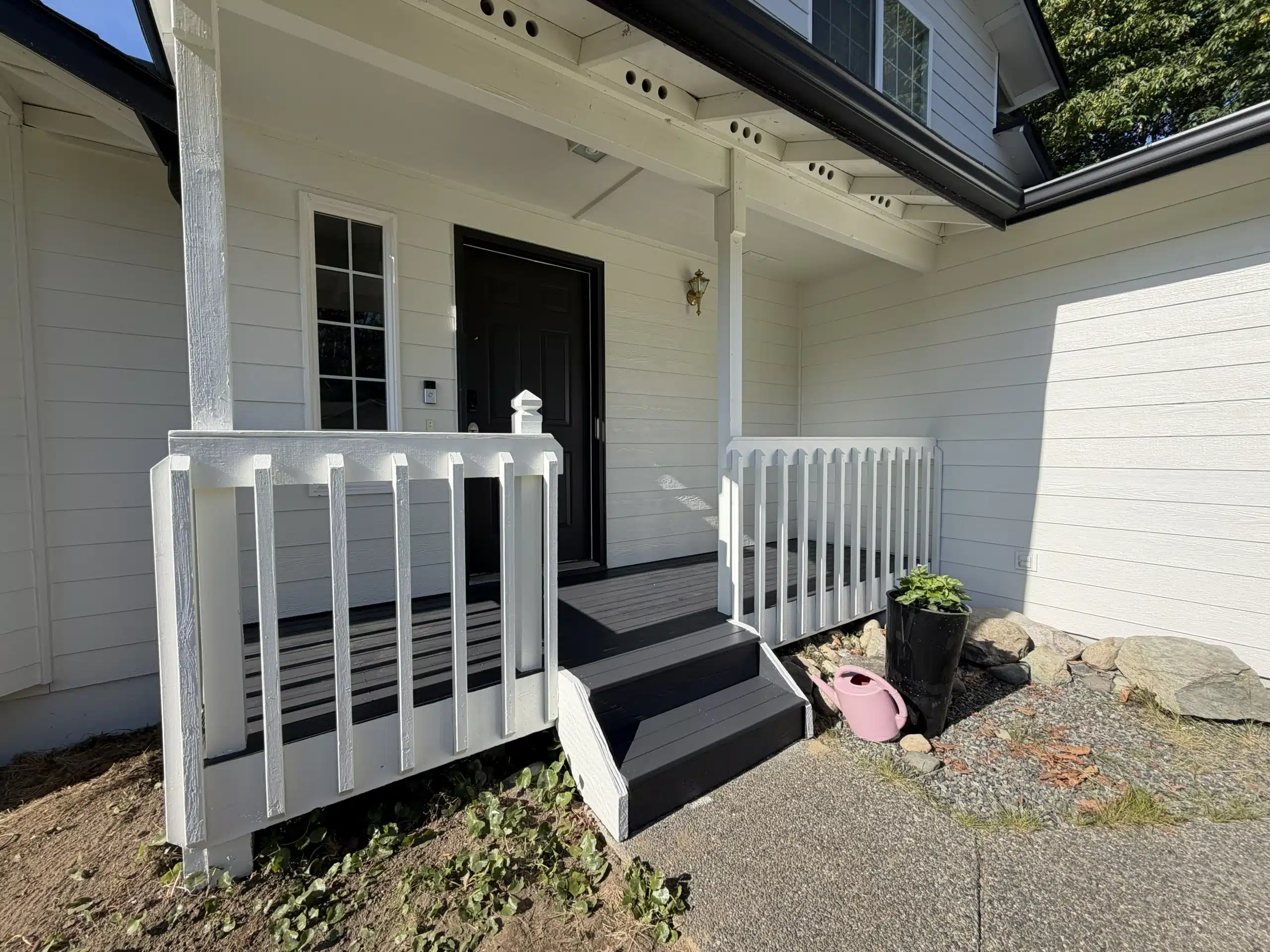 Freshly Painted White House Exterior with Black Door and Steps A beautifully painted white house exterior featuring a striking black front door and matching steps, enhancing curb appeal.