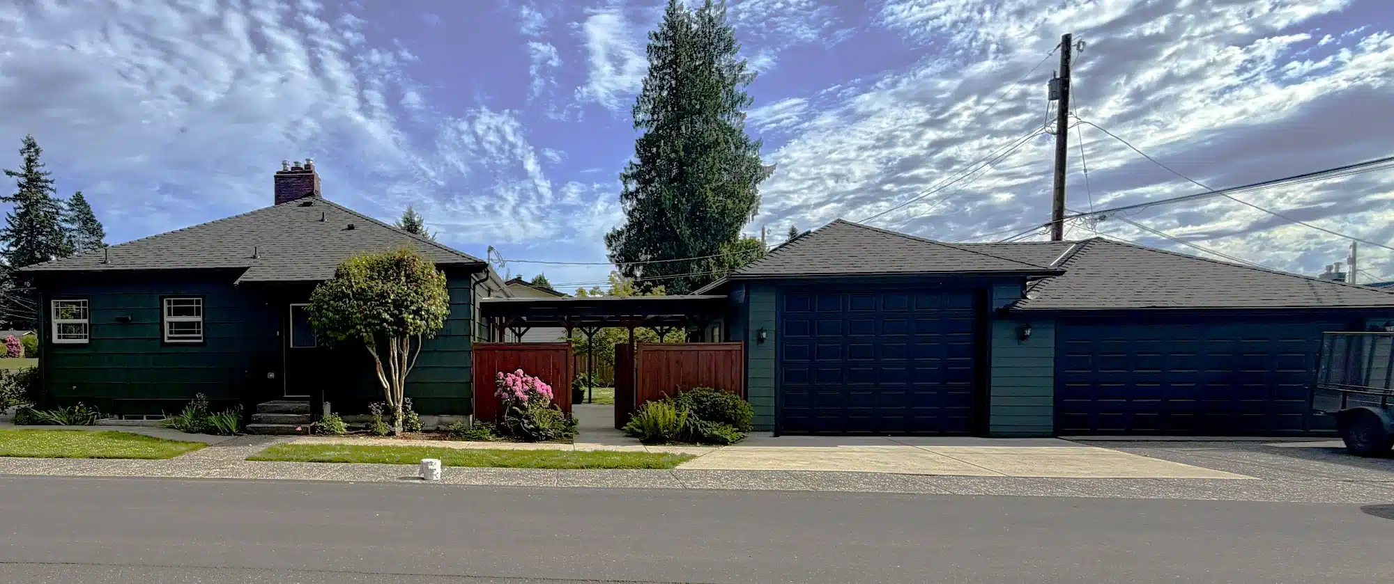 Dark Green and Navy Exterior Residential Painting Dark green and navy blue exterior residential painting on Seattle home with garage doors and landscaping